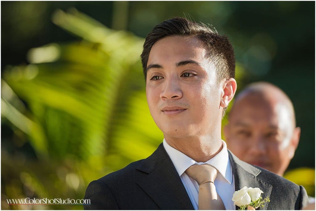 groom looking at bride walking down the aisle