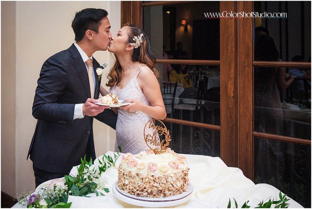Bride and groom kissing after cake cutting