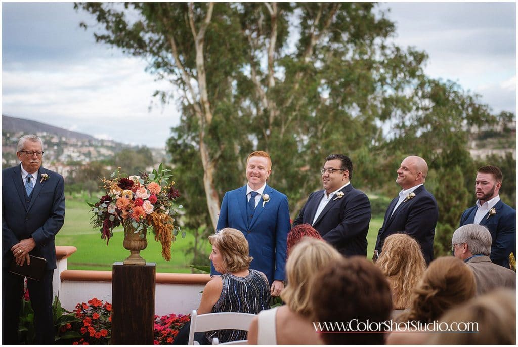 Groom looking at bride walking down the isle