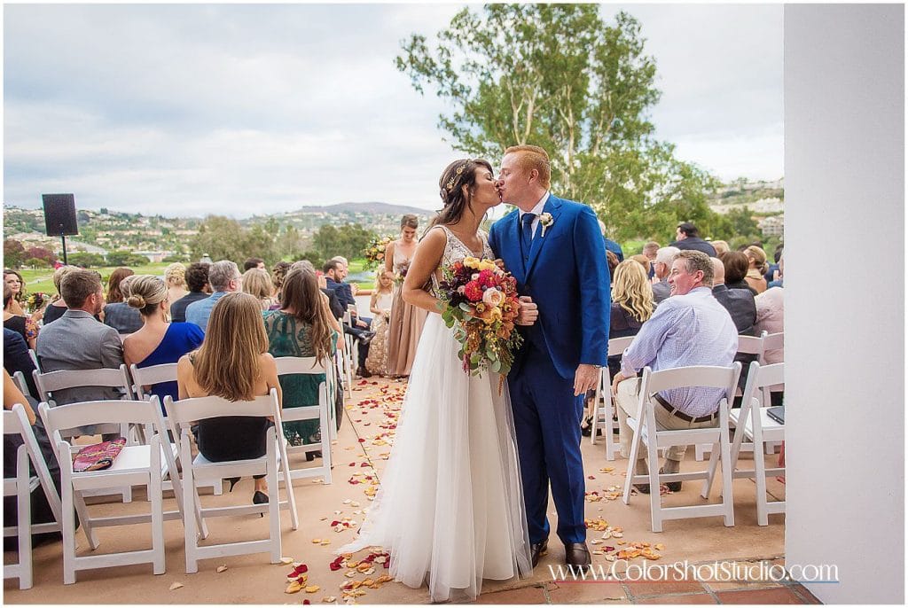Bride and groom kissing outside the wedding ceremony location